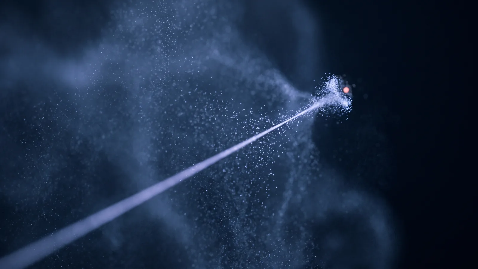 A single beam of light crossing a cloud of drifting particles and converging on one bright point